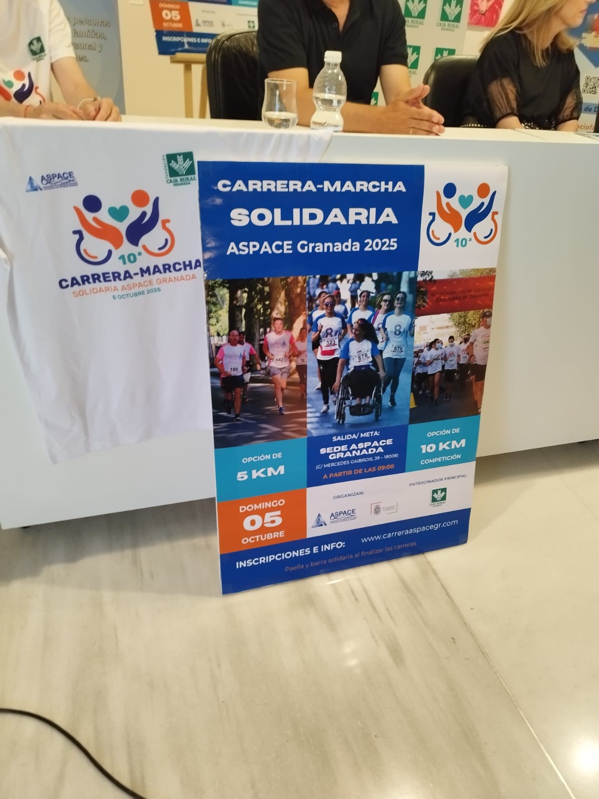 Cartel oficial de la 10ª Carrera-Marcha Solidaria ASPACE Granada 2025, con información sobre las fechas, recorridos de 5 y 10 km, ubicación de salida y meta, y logos de entidades colaboradoras. Incluye una imagen de participantes en ediciones anteriores.